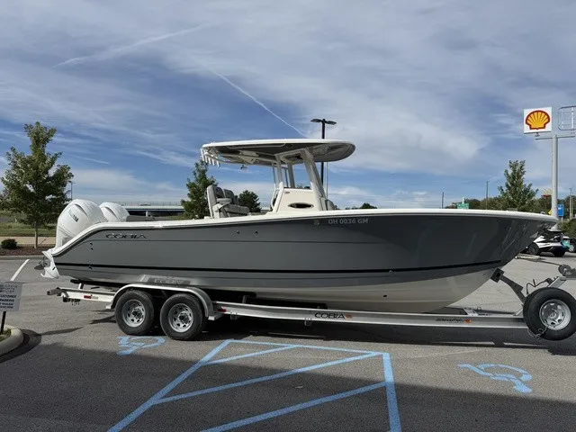 Slide: The Image of A 2024 Cobia 280 Center Console boat on a trailer in a parking lot. - 5