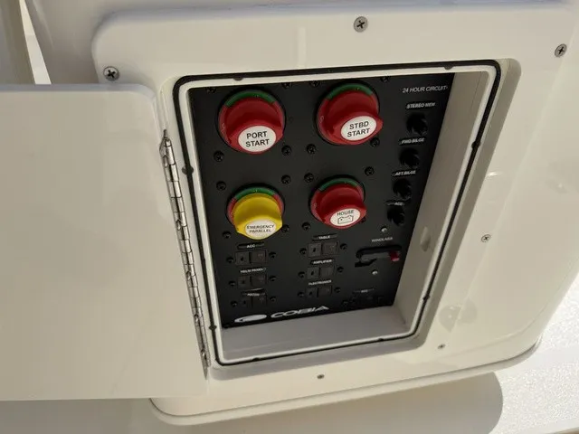 Slide: The Image of The image shows a control panel on a 2024 Cobia 280 Center Console boat with various switches. - 15