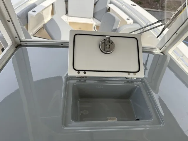 Slide: The Image of The image shows the cockpit of a 2024 Cobia 280 Center Console with an open storage compartment. - 23