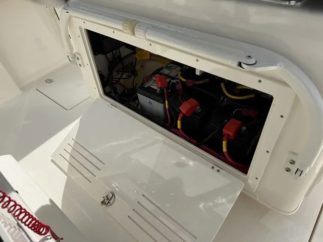 Slide: The Image of An open compartment on a Cobia 280 Center Console boat reveals batteries and wiring. - 17