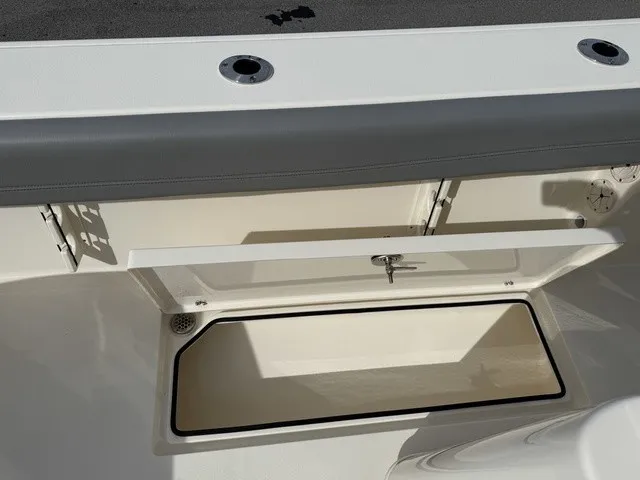 Slide: The Image of An open storage compartment on a 2024 Cobia 280 Center Console boat. - 13