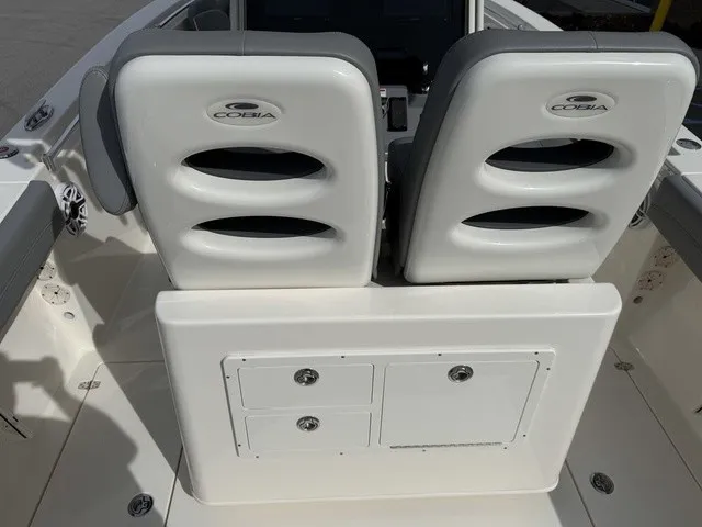 Slide: The Image of Two cushioned seats with Cobia logo on a boat, featuring storage drawers below. - 11
