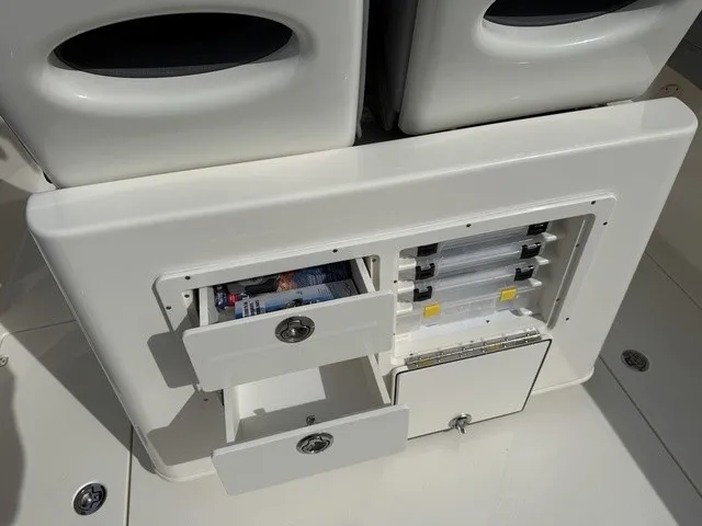 Slide: The Image of The image shows the storage area of a 2024 Cobia 280 Center Console boat with drawers and compartments. - 12