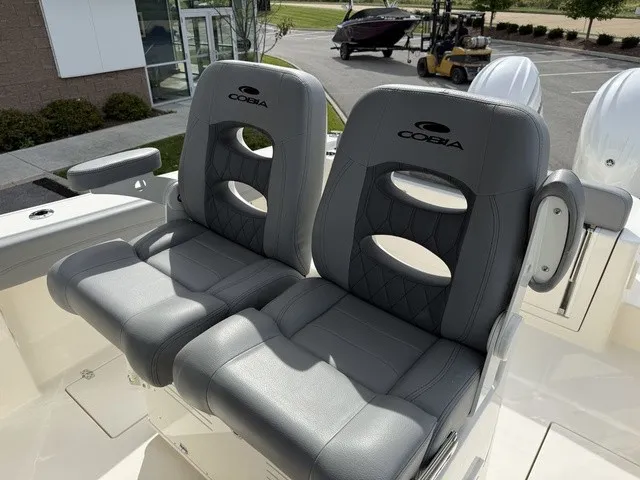 Slide: The Image of Two gray, cushioned seats with Cobia logo on a boat. - 18