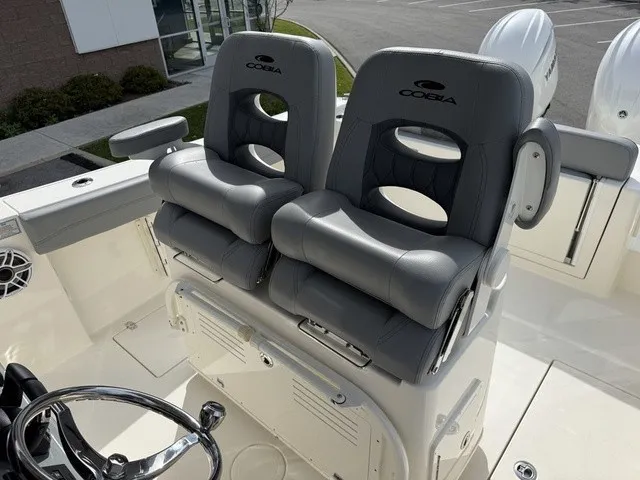 Slide: The Image of Two cushioned seats on a Cobia 280 Center Console boat, featuring a helm and speakers. - 16