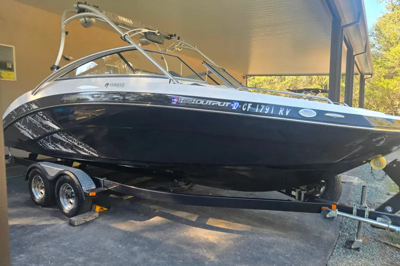 Slide: The Image of 2013 Yamaha Boats AR240 HO on trailer under a covered area. - 1