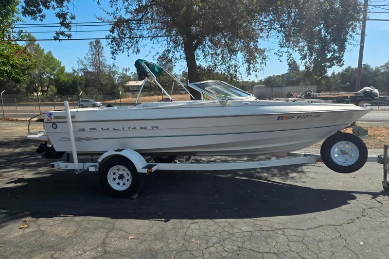 The Image of 2000 Bayliner 1950 Capri Classic boat on trailer, parked outdoors. - 1