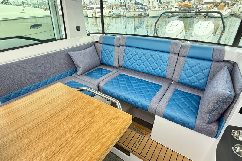 Slide: The Image of Luxurious interior of 2025 Axopar 37 XC Cross Cabin with blue quilted seating. - 13