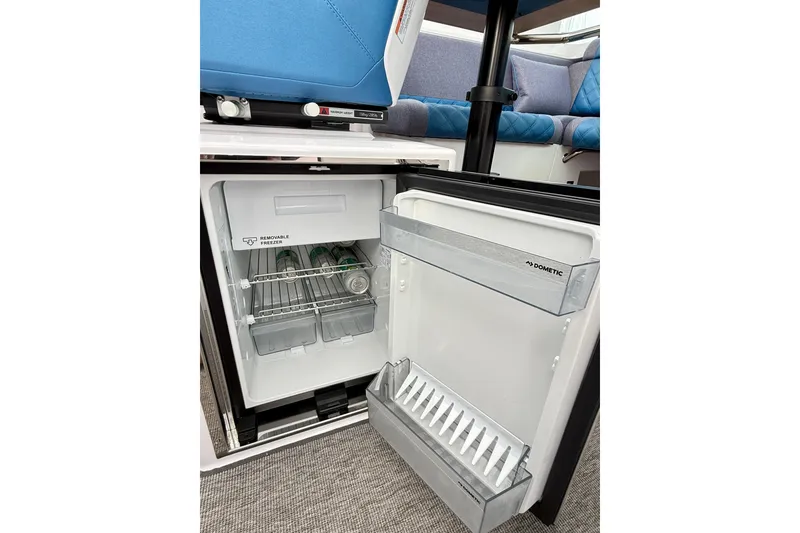 Slide: The Image of 2025 Axopar 37 XC Cross Cabin interior with open Dometic fridge, showcasing storage and seating. - 21