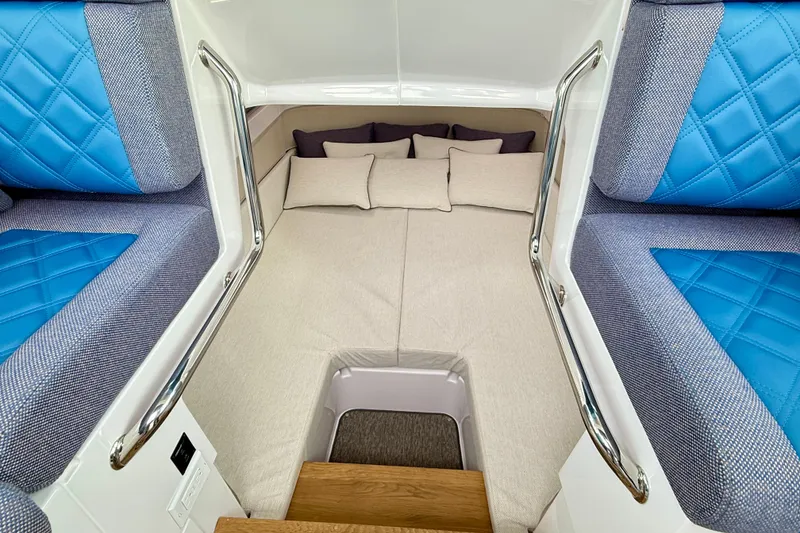 Slide: The Image of 2025 Axopar 37 XC Cross Cabin interior with blue seating and cozy sleeping area. - 18