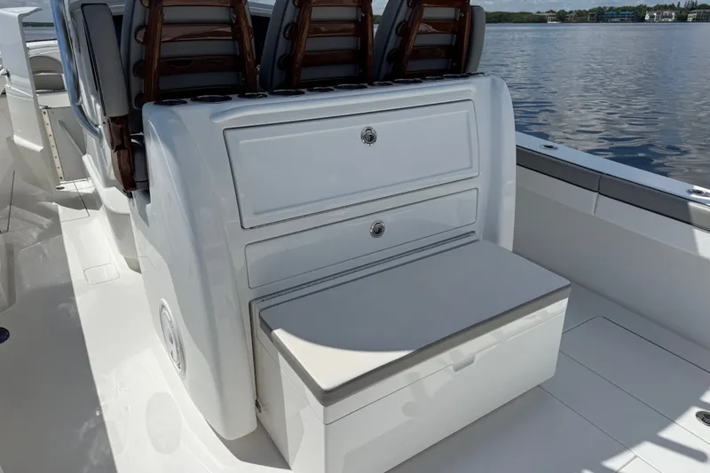 Slide: The Image of 2024 Valhalla V-33 boat interior with seating and storage, on calm water. - 17