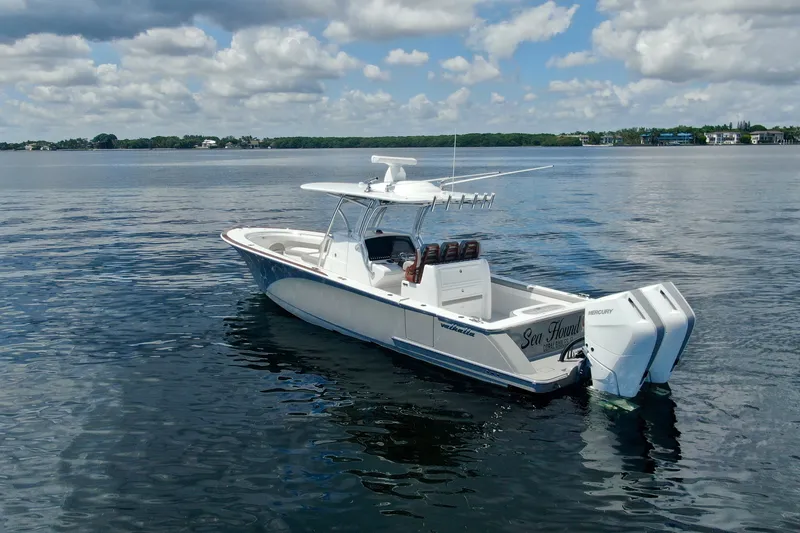Slide: The Image of 2024 Valhalla V-33 boat on calm water under a partly cloudy sky. - 2