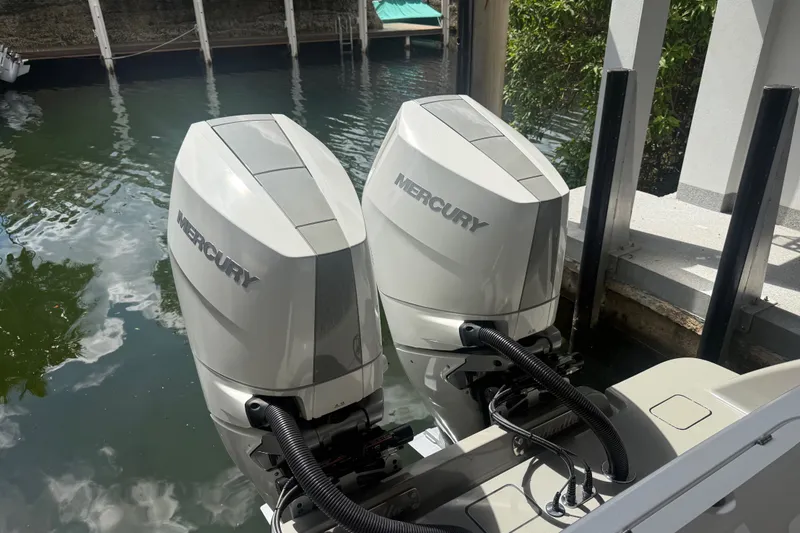 Slide: The Image of Twin Mercury outboard engines on a 2024 Valhalla V-33 boat docked by the water. - 42