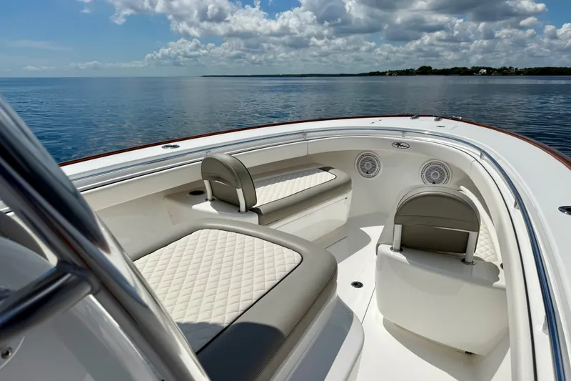 Slide: The Image of 2024 Valhalla V-33 boat interior with cushioned seating on calm water. - 35