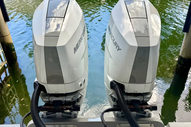 Slide: The Image of Twin Mercury outboard engines on a 2024 Valhalla V-33 boat, docked by the water. - 41