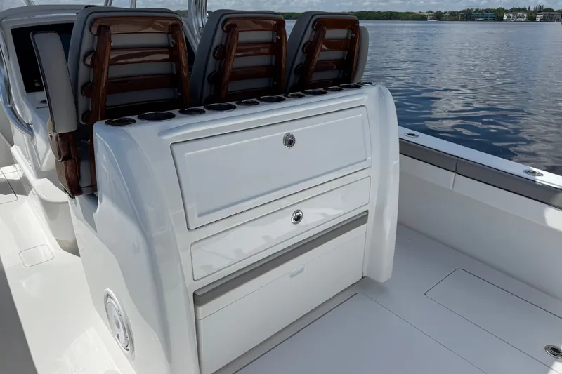Slide: The Image of 2024 Valhalla V-33 boat interior with seating and storage, on calm water. - 16