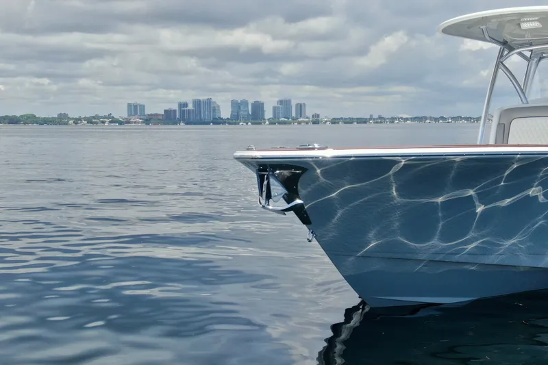 Slide: The Image of Valhalla V-33 boat on calm water with city skyline in background, 2024 model. - 7