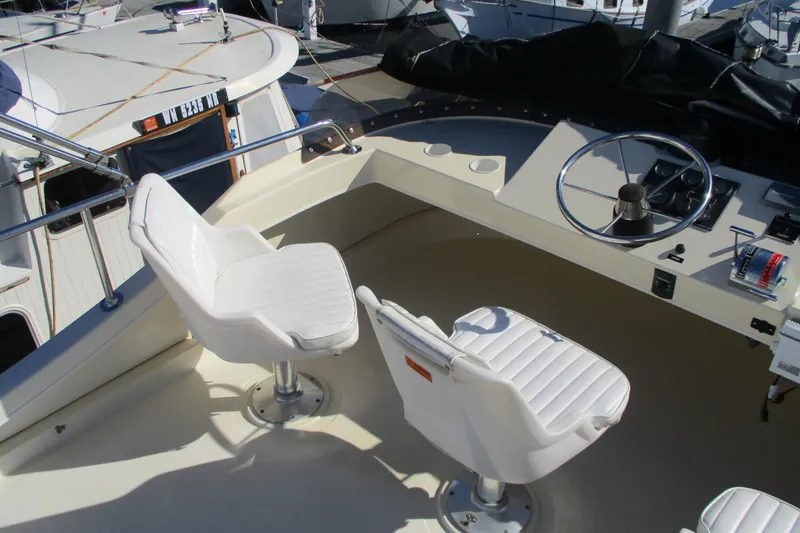 Slide: The Image of 2005 Camano 31 Troll boat helm with white captain chairs and steering wheel. - 18