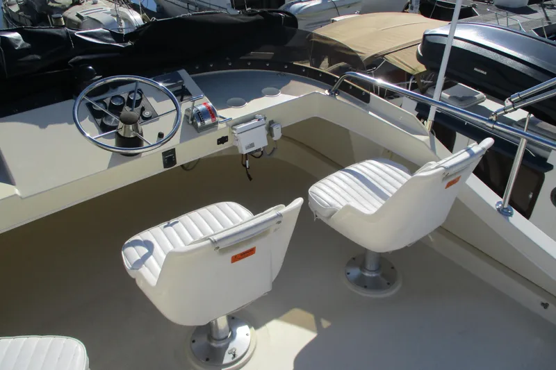 Slide: The Image of 2005 Camano 31 Troll boat helm with dual white captain chairs and steering controls. - 20