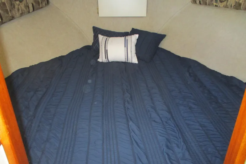Slide: The Image of Cozy sleeping area in 2005 Camano 31 Troll boat with blue bedding and pillows. - 15
