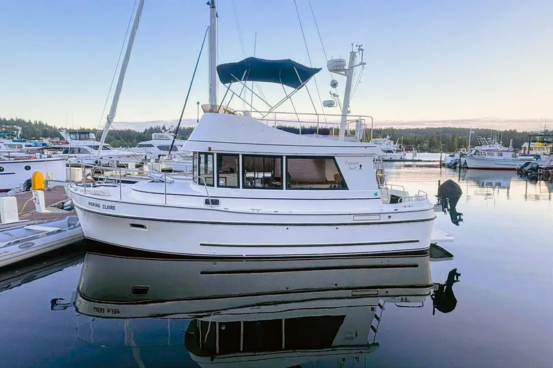 Slide: The Image of 2005 Camano 31 Troll boat docked in a serene marina setting. - 43