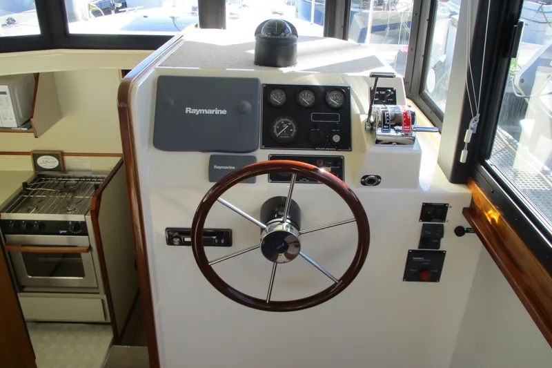 Slide: The Image of 2005 Camano 31 Troll helm with Raymarine equipment and wooden steering wheel. - 6