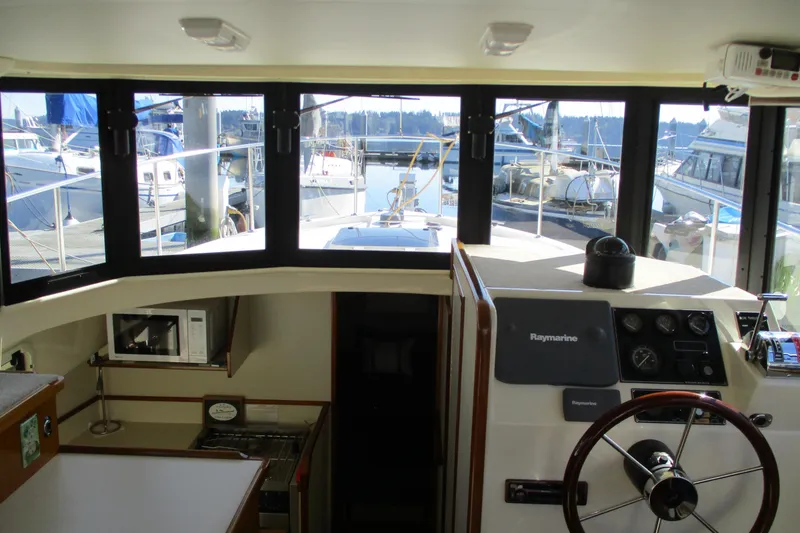 Slide: The Image of Interior view of 2005 Camano 31 Troll boat helm with marina background. - 4