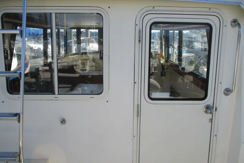 Slide: The Image of 2005 Camano 31 Troll boat cabin door and windows with marina view. - 26