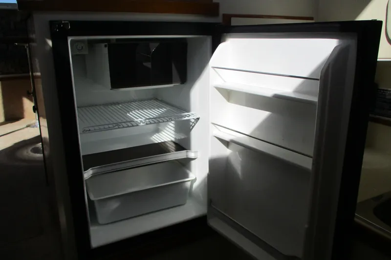 Slide: The Image of Open refrigerator inside a 2005 Camano 31 Troll boat, showing shelves and compartments. - 11