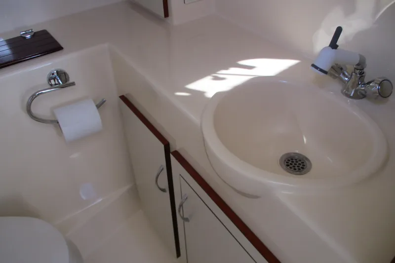 Slide: The Image of 2005 Camano 31 Troll boat bathroom with sink, faucet, and storage cabinets. - 16