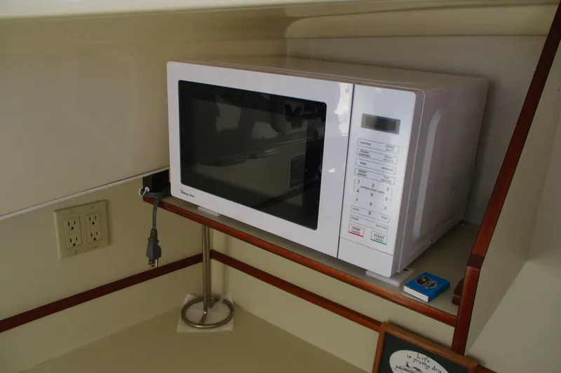 Slide: The Image of Microwave in 2005 Camano 31 Troll boat interior, placed on a wooden shelf. - 12