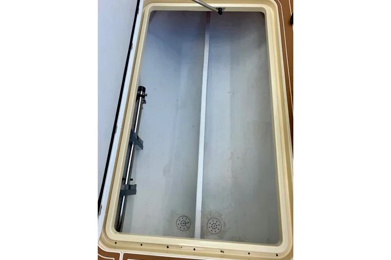 Slide: The Image of Open storage compartment in 2021 Conch 33 boat, featuring drainage system and hydraulic support. - 37