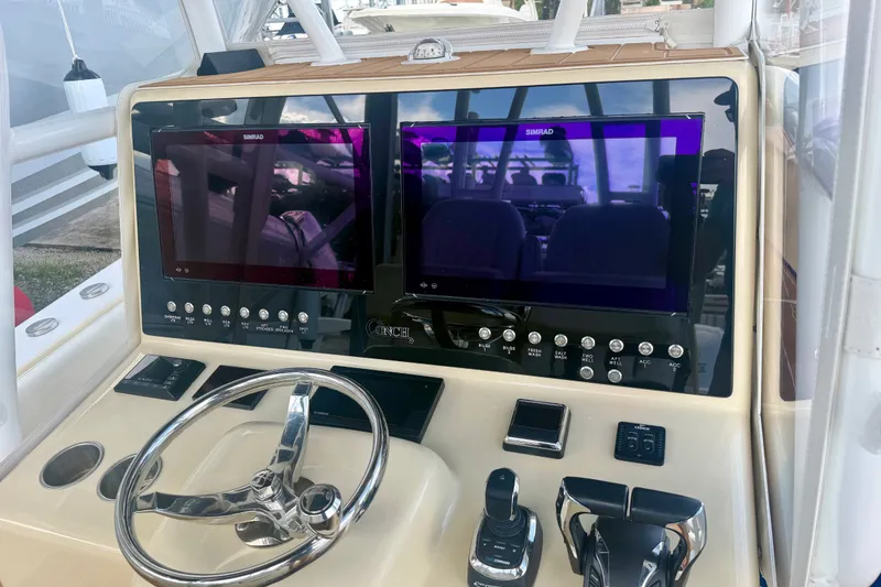Slide: The Image of 2021 Conch 33 boat dashboard with dual Simrad displays and steering wheel. - 12