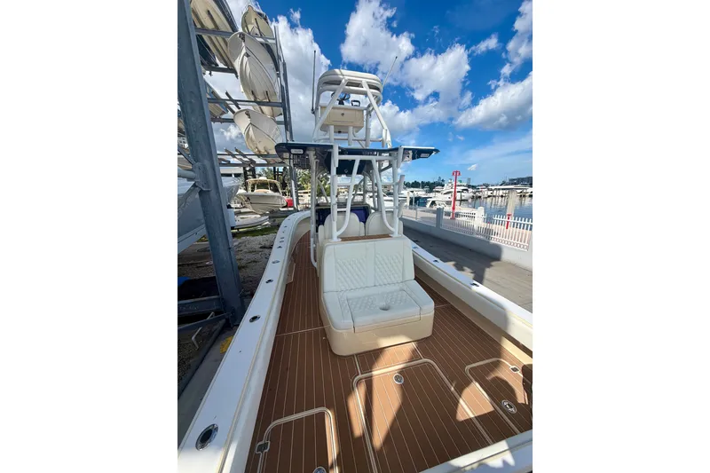 Slide: The Image of 2021 Conch 33 boat with wooden deck, docked at marina under blue sky. - 7