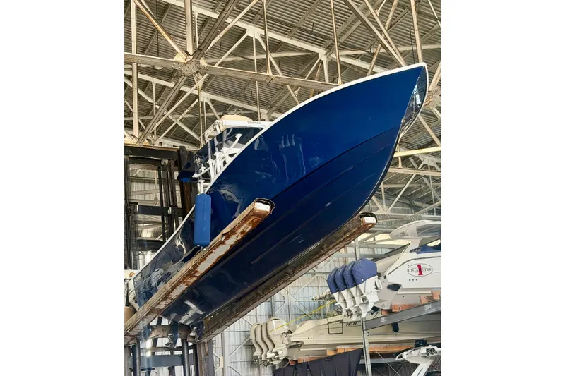 Slide: The Image of Blue 2021 Conch 33 boat in a warehouse, elevated on a lift. - 6