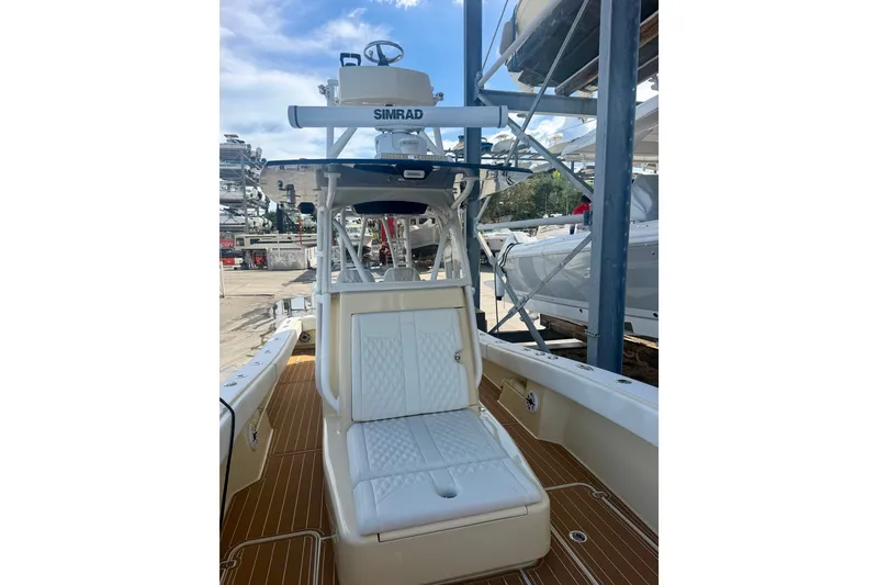 Slide: The Image of 2021 Conch 33 boat interior with white seating and Simrad electronics. - 13