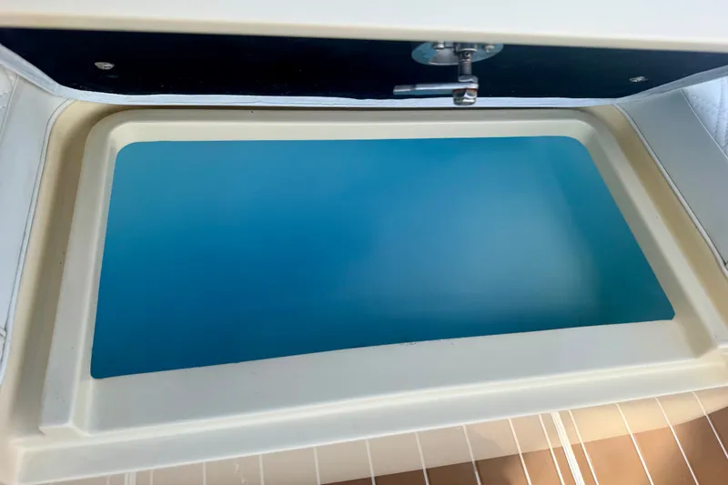 Slide: The Image of Open hatch on 2021 Conch 33 boat, showcasing blue interior compartment. - 29