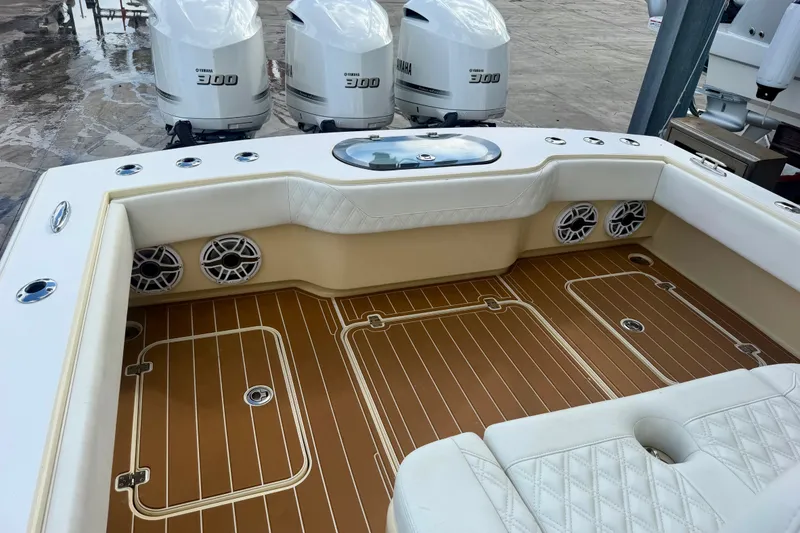 Slide: The Image of Luxury Conch 33 boat interior with Yamaha 300 engines, featuring cushioned seating and teak flooring. - 10
