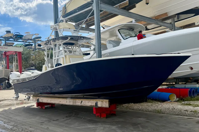 Slide: The Image of 2021 Conch 33 boat in storage, blue hull, marina setting, clear sky. - 2