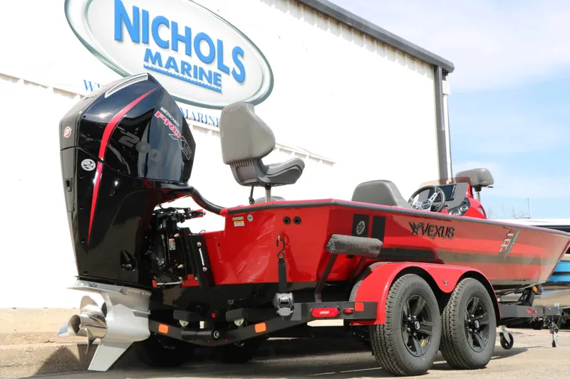 Slide: The Image of A red 2027 Vexus AVX 2080 boat on a trailer in front of a building with a "Nichols Marine" sign. - 12
