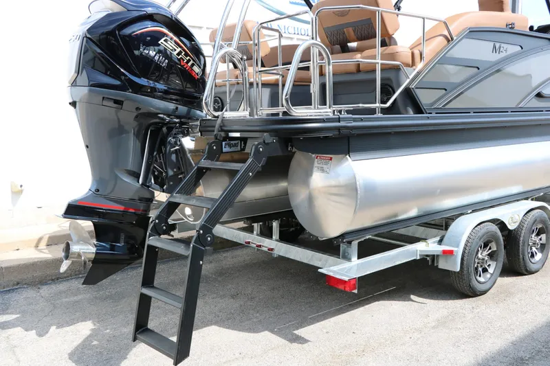 Slide: The Image of A 2027 Bennington 24 MSL Tri Toon on a trailer with an outboard motor and ladder. - 23