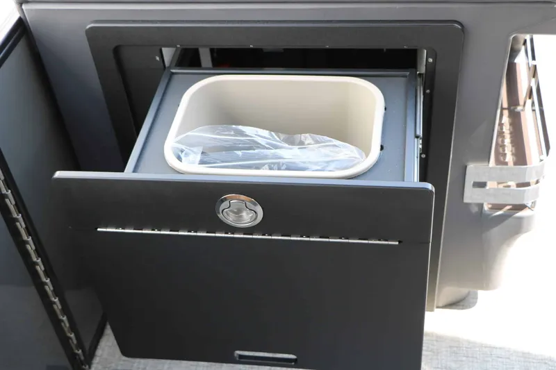 Slide: The Image of A pull-out trash bin in a cabinet on a Bennington 24 MSL Tri Toon boat. - 42