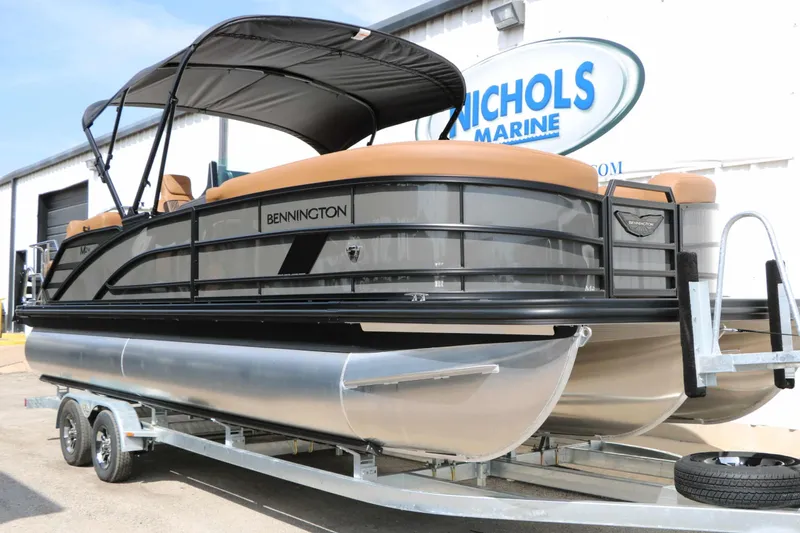 Slide: The Image of A 2027 Bennington 24 MSL Tri Toon on a trailer. It features black railings and a sunshade. - 6