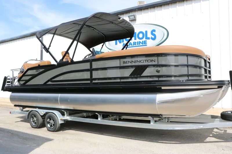 The Image of A sleek 2027 Bennington 24 MSL Tri Toon on a trailer in front of a building. - 1