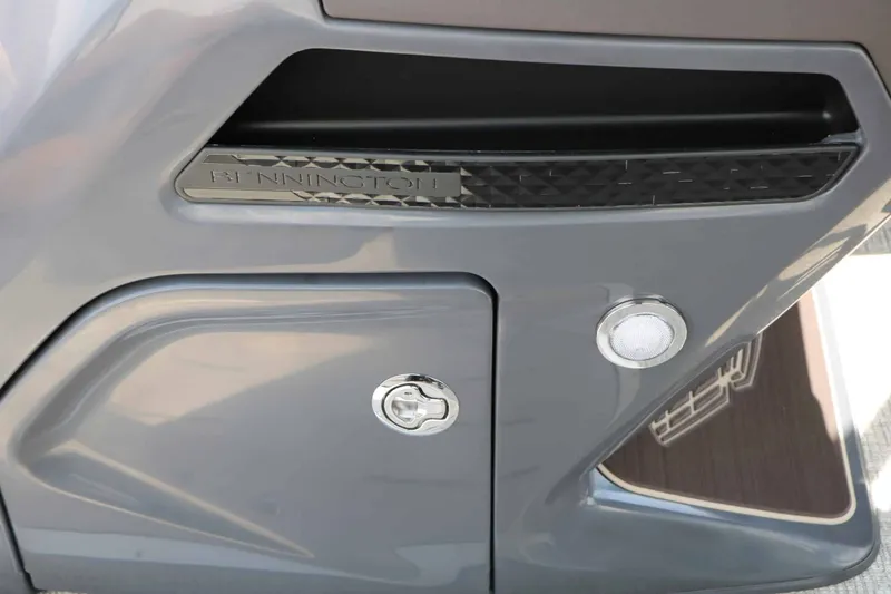 Slide: The Image of Close-up of a gray boat section with Bennington logo and storage compartment. - 44
