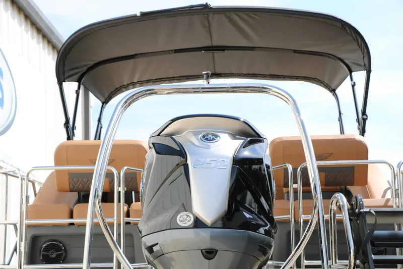 Slide: The Image of A 2027 Bennington 24 MSL Tri Toon with a large outboard motor and a sun canopy. - 17