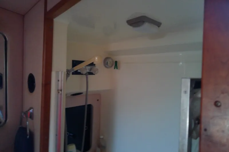Slide: The Image of Interior of 1989 Sea Ray 440 Aft Cabin yacht bathroom with showerhead and mirror. - 38