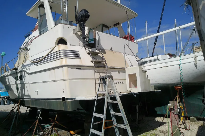 Slide: The Image of 1989 Sea Ray 440 Aft Cabin yacht on dry dock with ladder and equipment. - 7