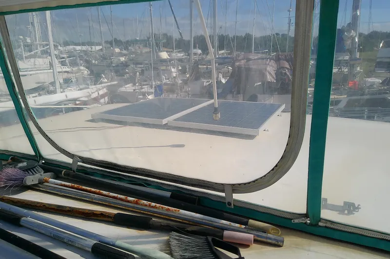 Slide: The Image of 1989 Sea Ray 440 Aft Cabin with solar panels, marina view through window. - 15