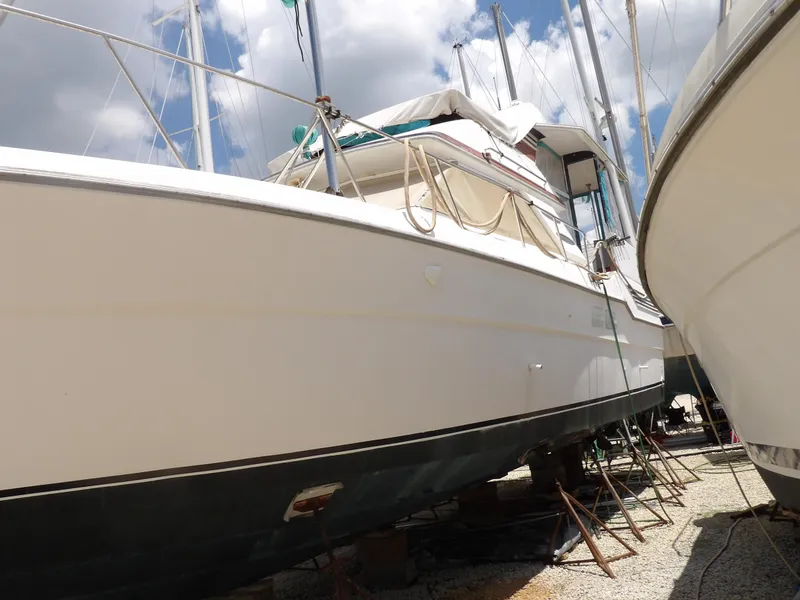 Slide: The Image of 1989 Sea Ray 440 Aft Cabin yacht on dry dock under a cloudy sky. - 4